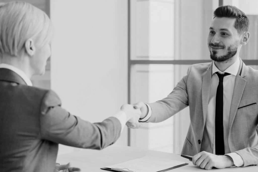 Deux professionnels se serrant la main autour d’une table